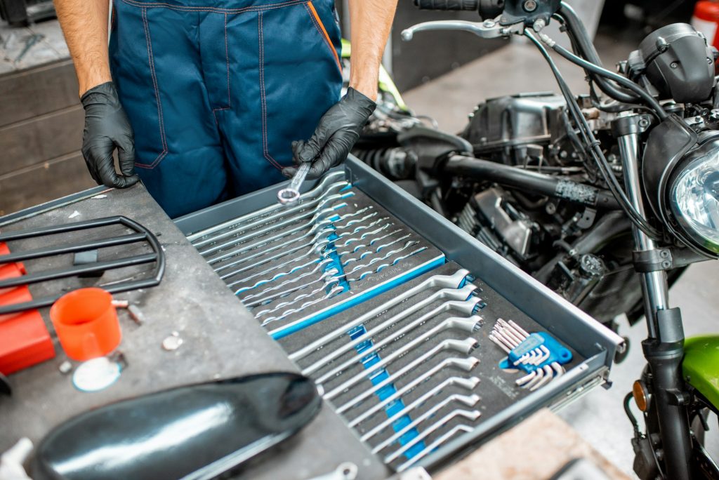 Mechanic with wrenches in the workshop
